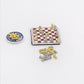 Miniature chessboard with gold and silver chess pieces plus small extra piece parts