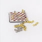 Miniature chessboard accessory with red-and-white squares and gold/silver chess pieces