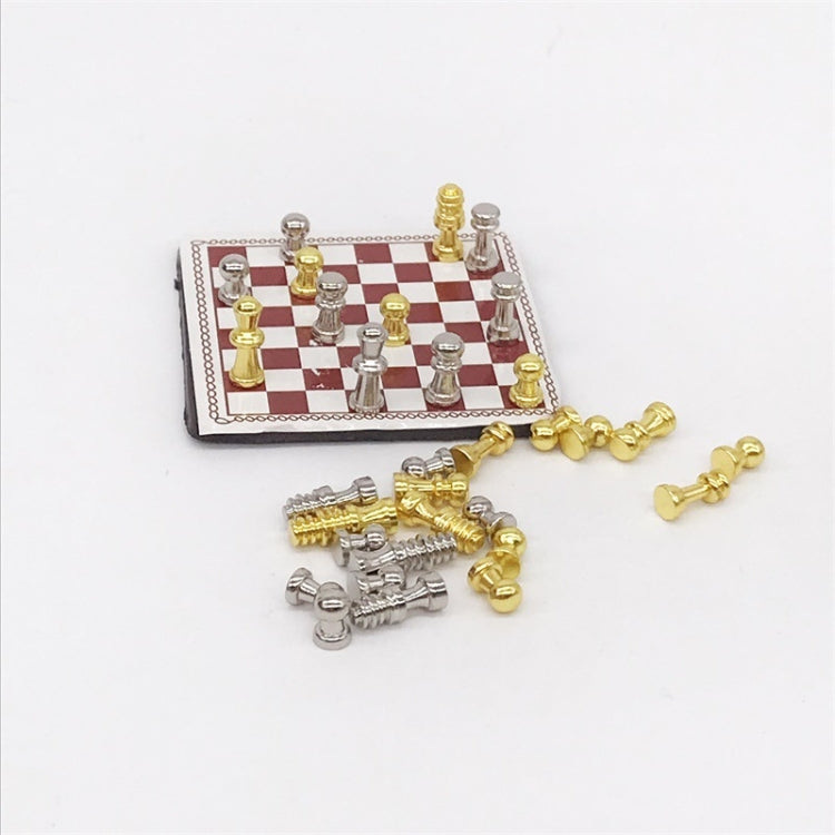Miniature chessboard accessory with red-and-white squares and gold/silver chess pieces