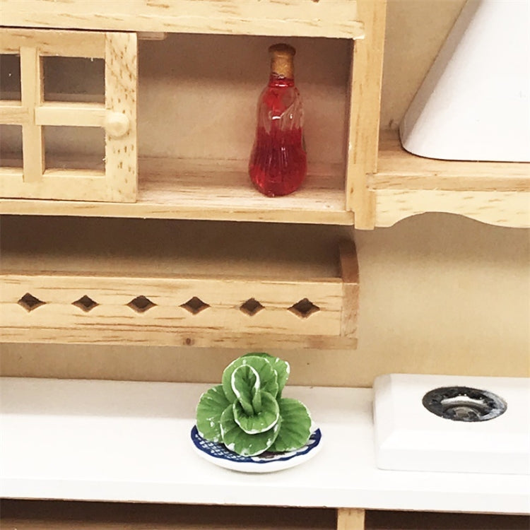 Mini faux cabbage toy on small blue-and-white plate inside dollhouse shelf