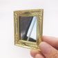 Mini wall mirror toy in hand, ornate gold square frame with reflective center
