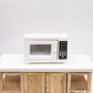 White miniature microwave oven model with side handle, window door, and keypad panel