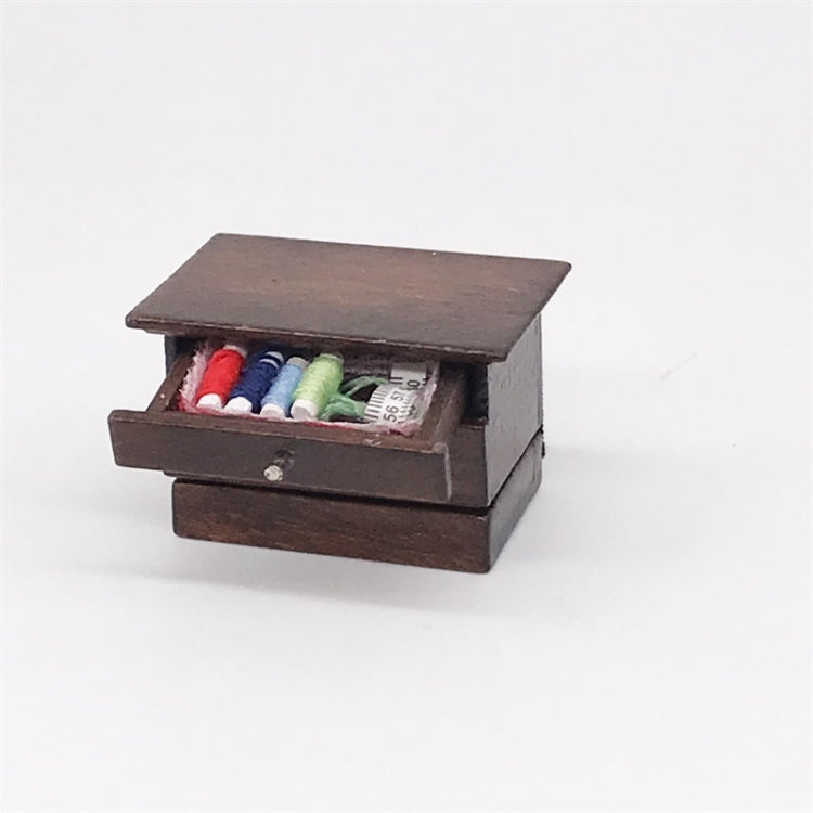 Mini wooden sewing box toy with front drawer open, colorful thread spools inside
