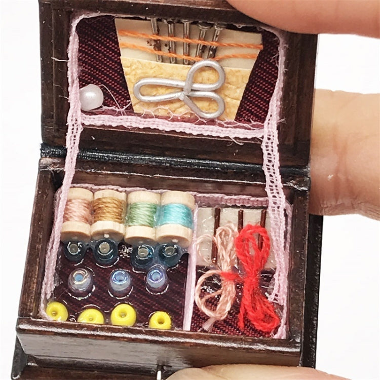 Close-up of mini wooden sewing box interior with scissors, spools, and buttons
