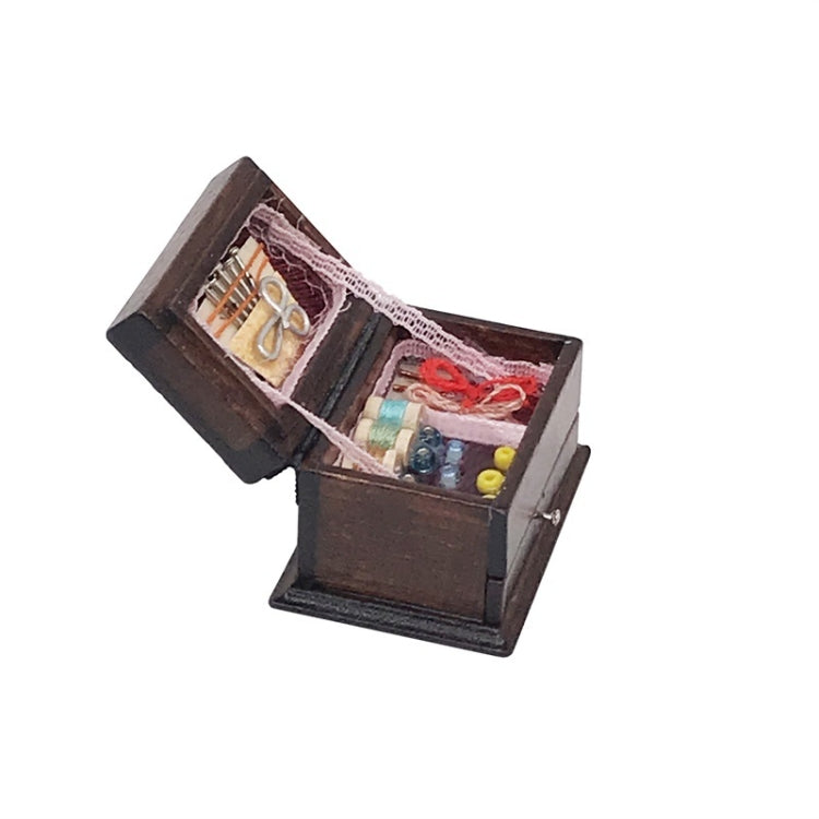 Mini wooden sewing box toy open sideways, showing thread spools and sewing notions