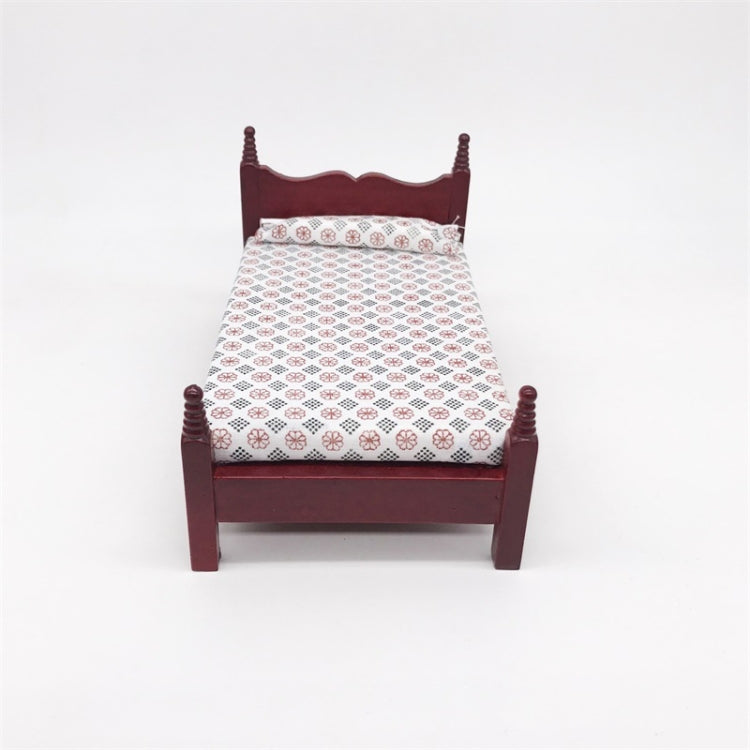Front view of mini dollhouse single bed toy with dark maroon frame and patterned white bedding