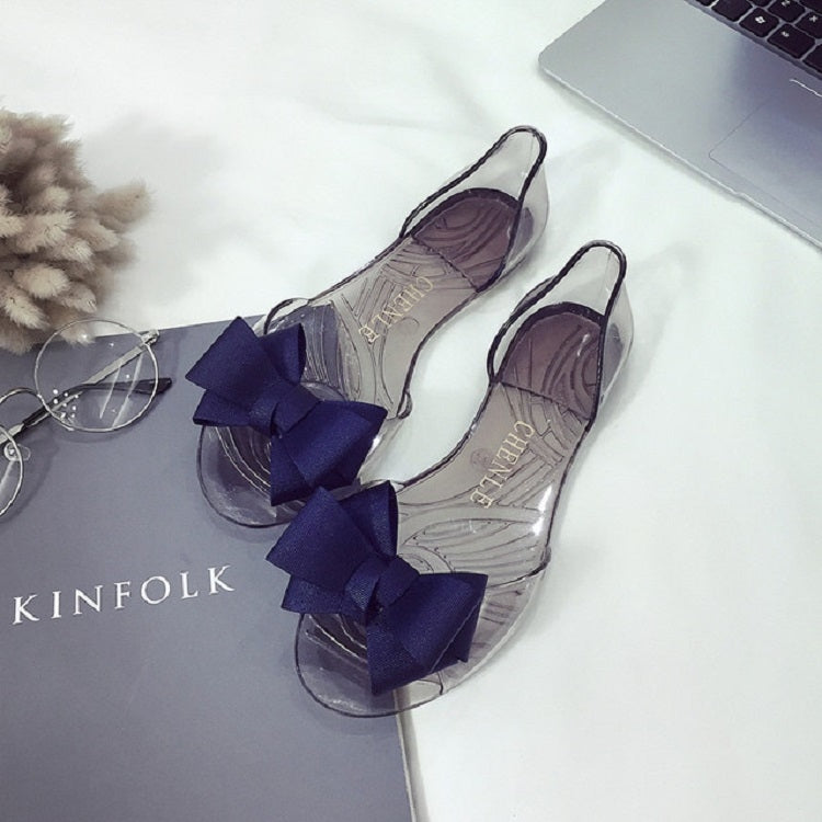 Transparent flat jellyfish-mouth shoes with dark bow accents and low profile sole