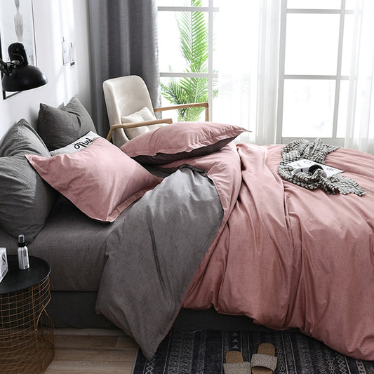 Pink duvet bedding set with gray pillows and plaid-patterned accent pillow