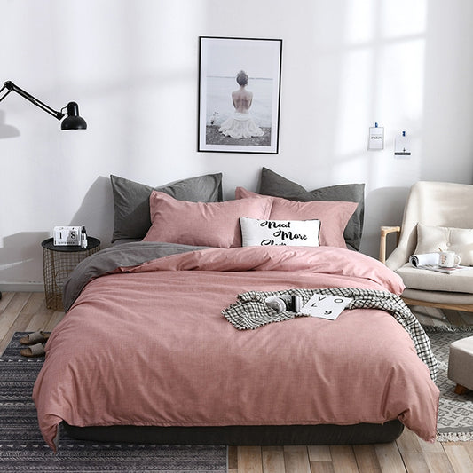 Pink and gray bedding set with plaid-patterned accent pillow and matching duvet
