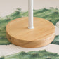 Round wooden base with vertical white post, on green patterned fabric