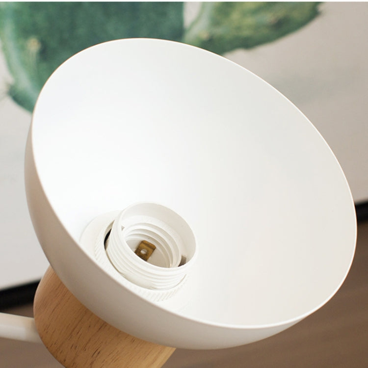 White lamp shade with exposed socket and threaded bulb holder on a wood base