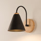 LED wall bedside lamp with black fabric shade and round wood backplate on an arched black arm