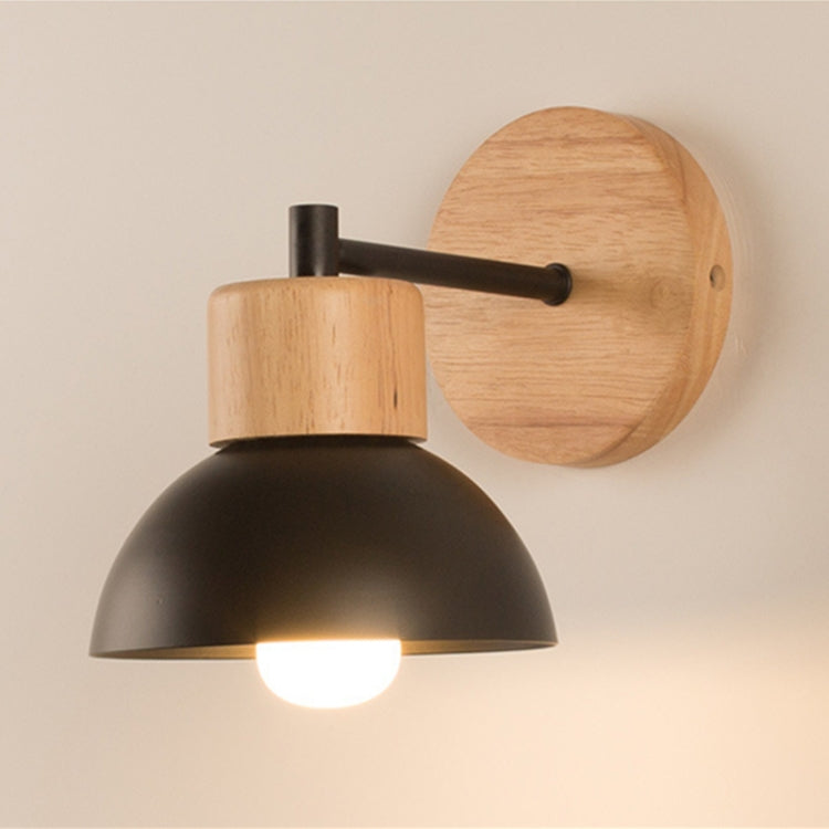 LED wall lamp with black dome shade, black arm, and round light-wood backplate, lit