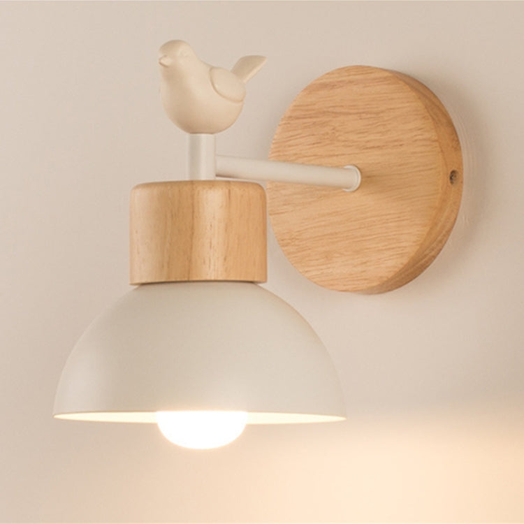 LED wall lamp with bird finial, white arm, light-wood backplate, and lit white shade