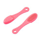 Pink silicone face cleansing brush pair with dense textured bristles and loop handles