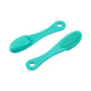 Green silicone face cleansing brush pair with dense textured bristles and loop handles