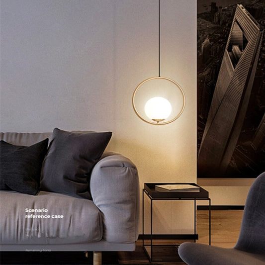 Round copper pendant lamp with circular gold ring and lit white glass diffuser