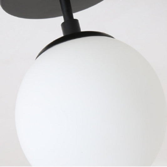 Close-up of black ceiling lamp stem under frosted globe shade