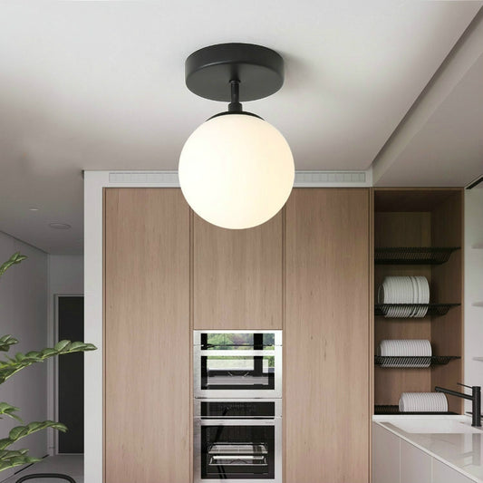 Black ceiling lamp with frosted globe shade and round mounting plate