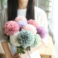 Simulated dandelion flower bouquet with pink, lavender, and pastel blooms and green leaves
