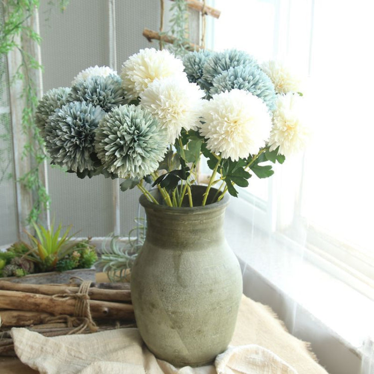 Simulated dandelion flower bouquet with pale green and blue ball blooms in a vase