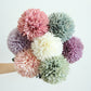Simulated dandelion flower bouquet with mixed pastel ball blooms and green leaves