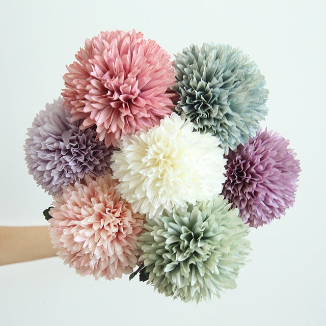 Simulated dandelion flower bouquet with mixed pastel ball blooms and green leaves