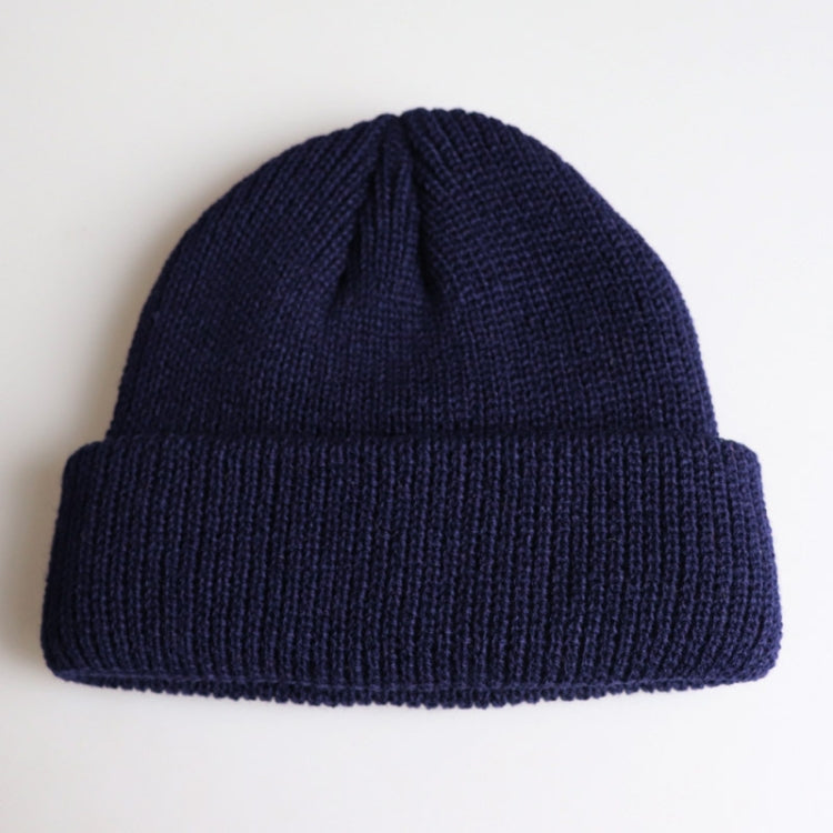 Navy ribbed knit beanie with folded cuff and small top knot detail
