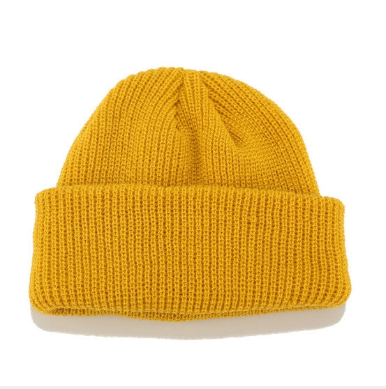 Yellow ribbed knit beanie with folded cuff and small top knot detail