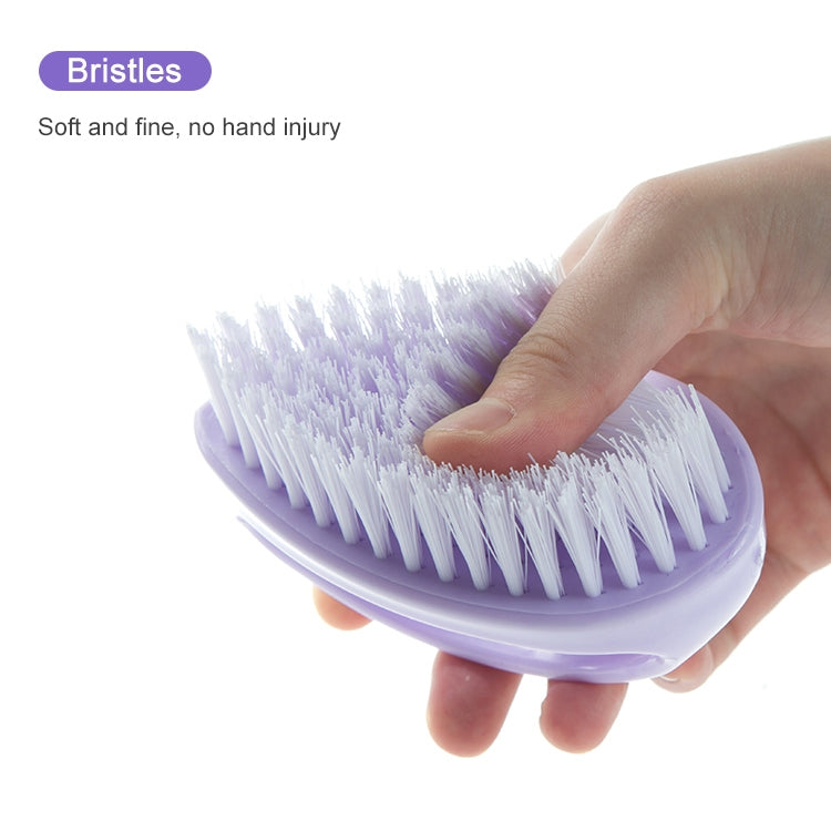Purple soft cleaning brush held in hand, close-up of fine bristles