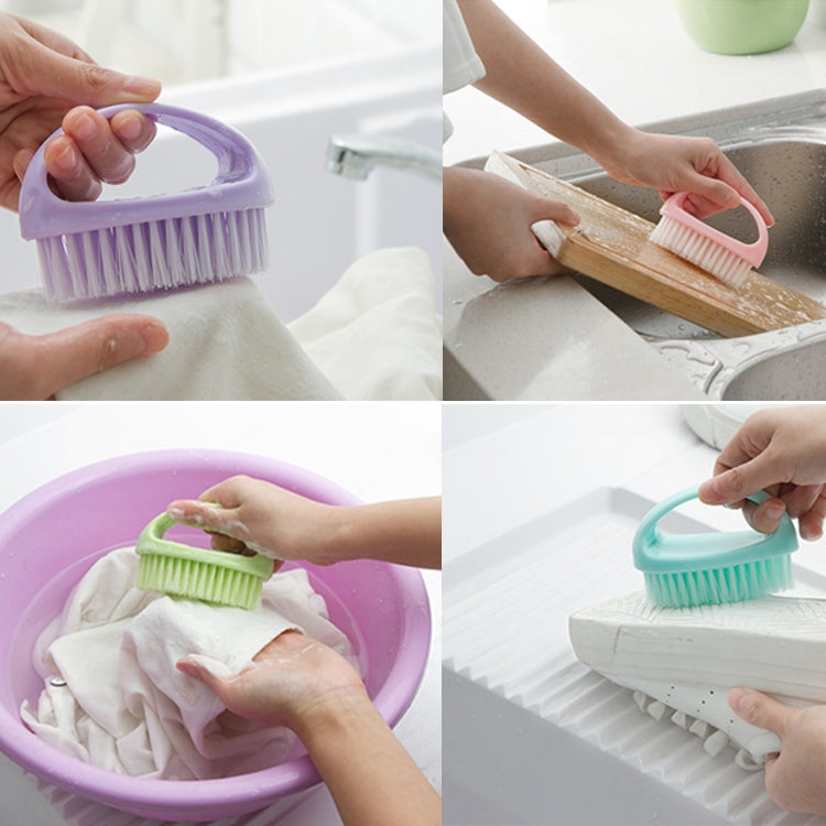 Two handheld cleaning brushes (purple and teal/green) being used for washing