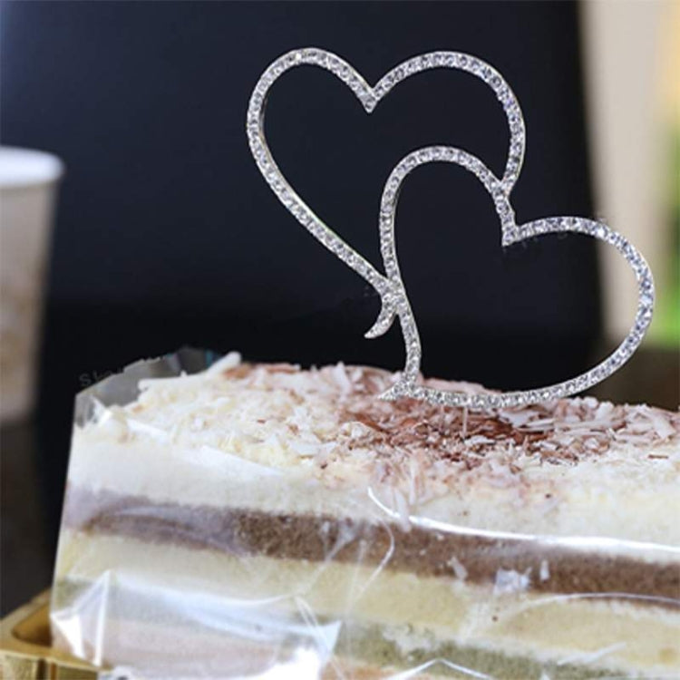 Crystal heart cake topper with two stacked hearts and two metal sticks on cake