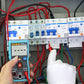 Teal mini digital multimeter held with red and black test leads for measurements