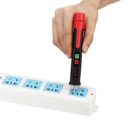 Non-contact voltage tester pen with red top and clear probe, held above a power strip