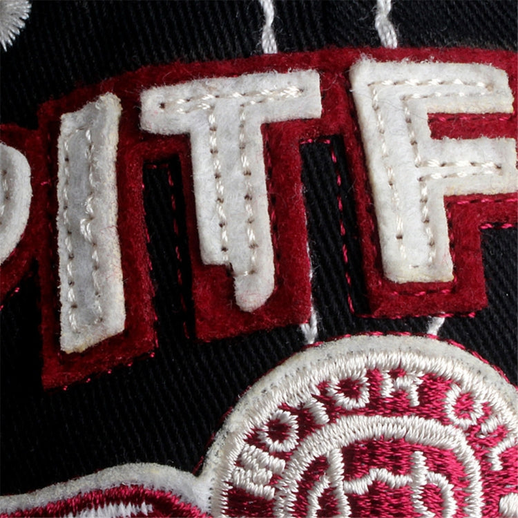 Red and white embroidered lettering patch on black cap, detailed stitch border