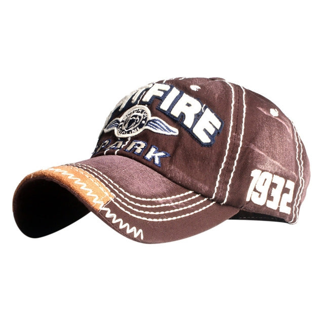 Brown baseball cap with embroidered FIRE patch, ARK text, stitched brim with contrast stitching