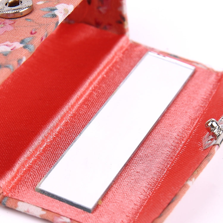 Close-up of peach floral makeup mirror case interior with hinged mirror panel