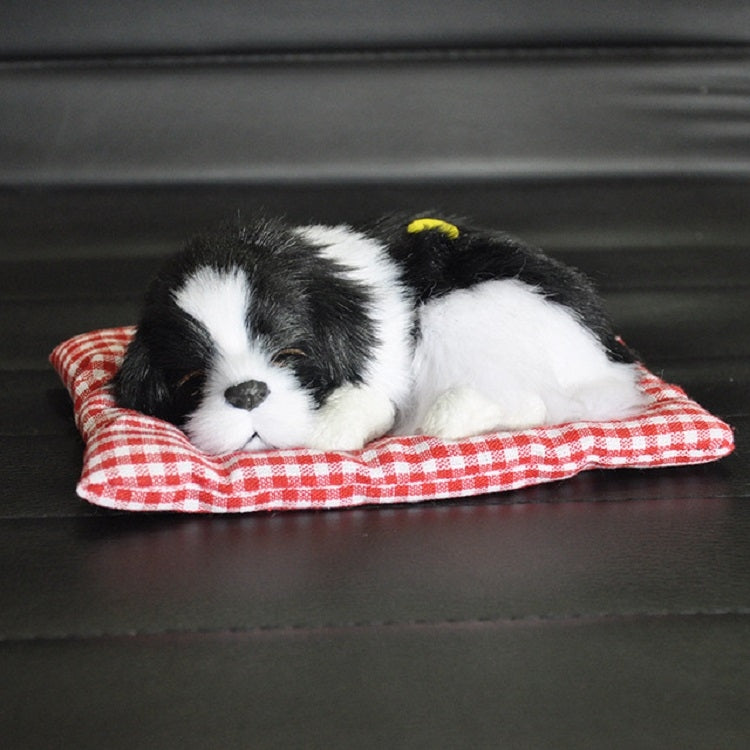 Plush sleeping dog ornament toy, black and white fur, in red plaid bed
