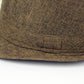 Close-up of brown woven sun visor hat brim with stitched decorative patch.