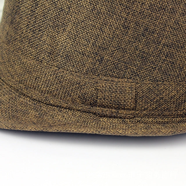 Close-up of brown woven sun visor hat brim with stitched decorative patch.