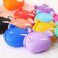Close-up of assorted silicone fish coin purses, including blue and purple faces
