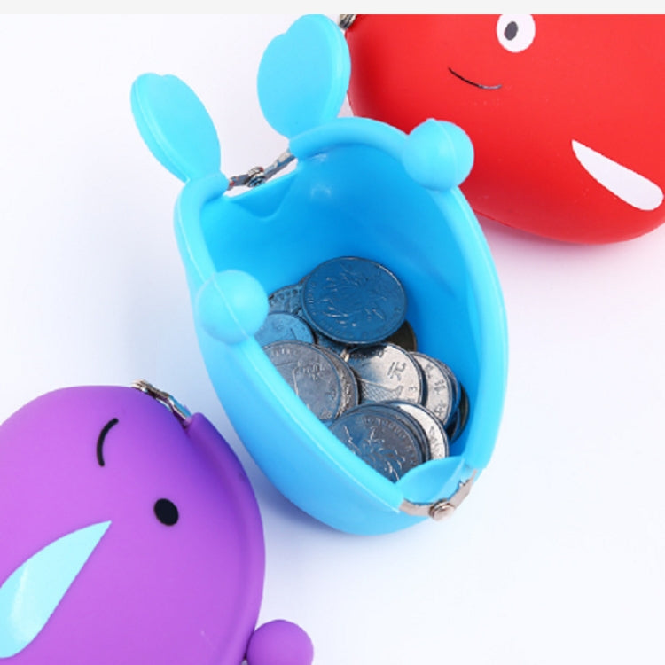 Open blue fish silicone coin purse with coins inside, next to a purple purse