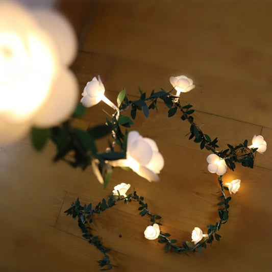 Circular arrangement of rose-flower LED light garland with green vine leaves