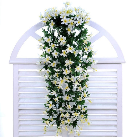 Artificial white lily vine wall hanging with leafy green stems, front view