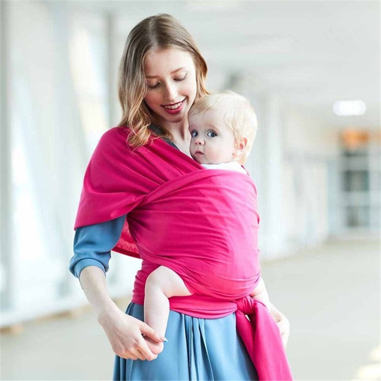 Infant multifunction sling in hot pink wrap style, carrying baby