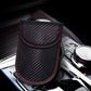 RFID key fob shielding pouch placed on dashboard, carbon-fiber texture with red stitching