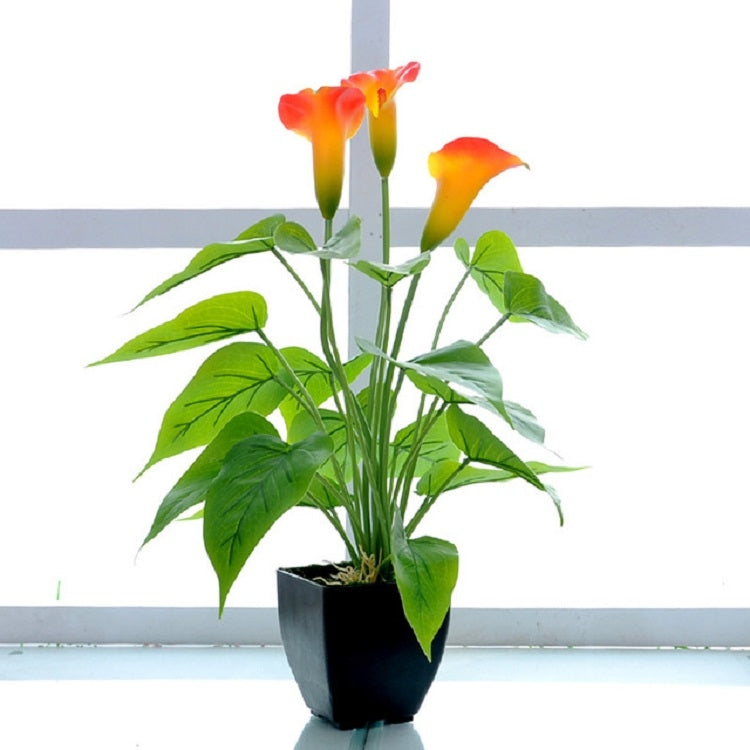Artificial calla flower potted plant, orange and yellow calla blooms with green leaves, black pot
