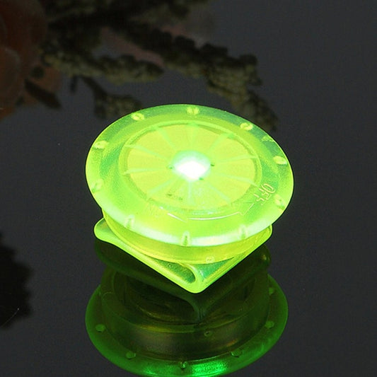 Green LED mini shoe clip light, close-up of round glowing lens for night visibility.