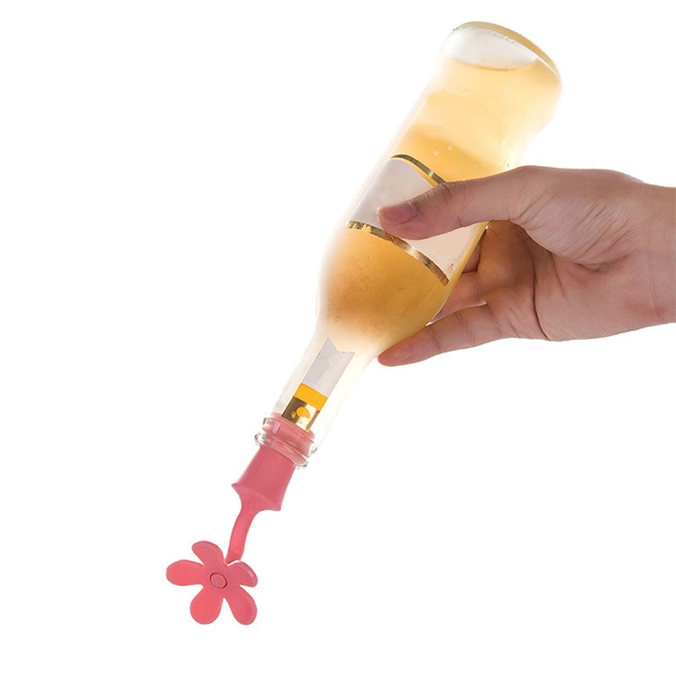 Hand holding a bottle with a red/pink flower-shaped silicone stopper