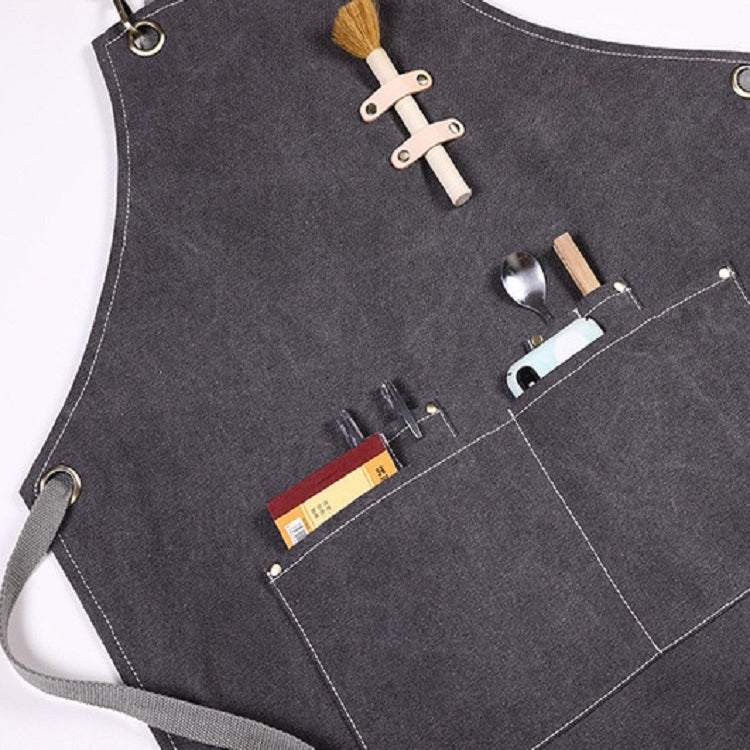 Dark grey thick canvas apron close-up with front pockets and small tool compartments
